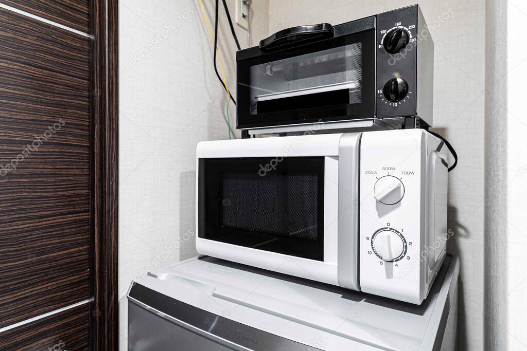 Microwave and mini oven on the fridge in the room
