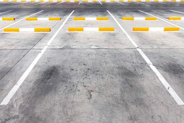 An empty car park and white lines outside the building