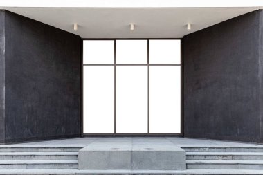 Binanın girişinde büyük alüminyum kapılar ve siyah taş duvarlar var.