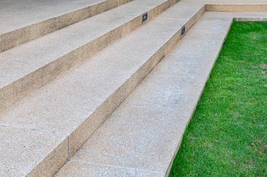 Kahverengi terrazzo merdivenleri ve evin dışında yeşil çimenler.