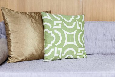 Oturma odasının iç tarafında uzun tahta bir hasır kanepe ve pamuk yastıklar.