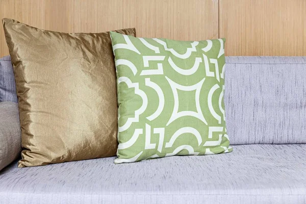 Oturma odasının iç tarafında uzun tahta bir hasır kanepe ve pamuk yastıklar.