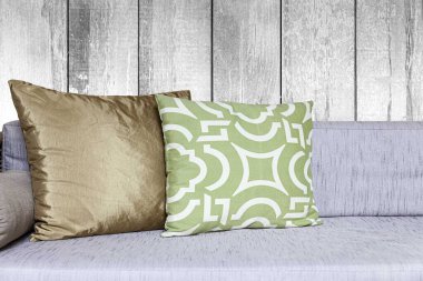 Oturma odasının iç tarafında uzun tahta bir hasır kanepe ve pamuk yastıklar.