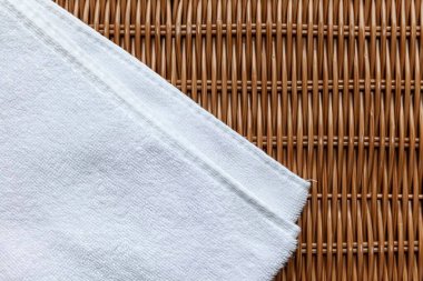 Kahverengi ahşap bir masada katlanmış temiz beyaz havlular..