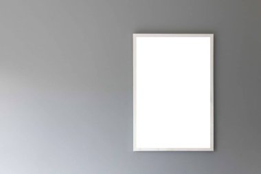 Pürüzsüz gri bir duvarda boş beyaz fotoğraf çerçevesi