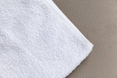 Kahverengi ahşap bir masada katlanmış temiz beyaz havlular..