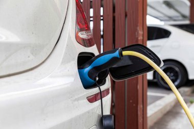 Elektrikli arabalar için park yerindeki araba şarjına takılı arabalar.