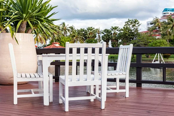 White wooden dining table by the pool inside the resort