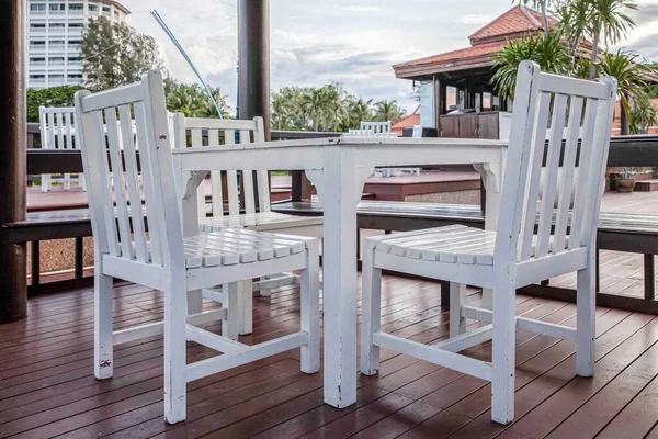 White wooden dining table by the pool inside the resort