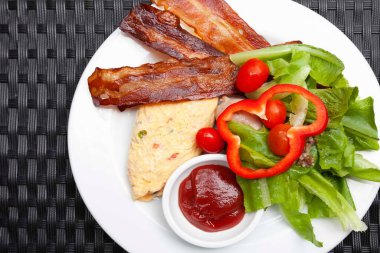 Batı kahvaltısı, çırpılmış yumurta, pastırma ve domates soslu taze sebze.