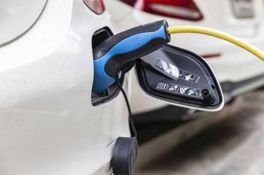 Elektrikli arabalar için park yerindeki araba şarjına takılı arabalar.