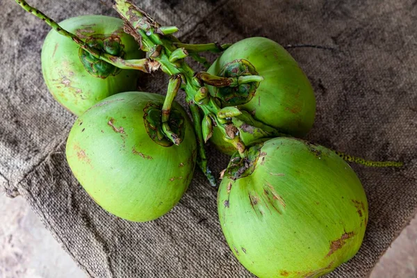 鲜绿色的椰子放在水果店的木制桌子上 — 图库照片