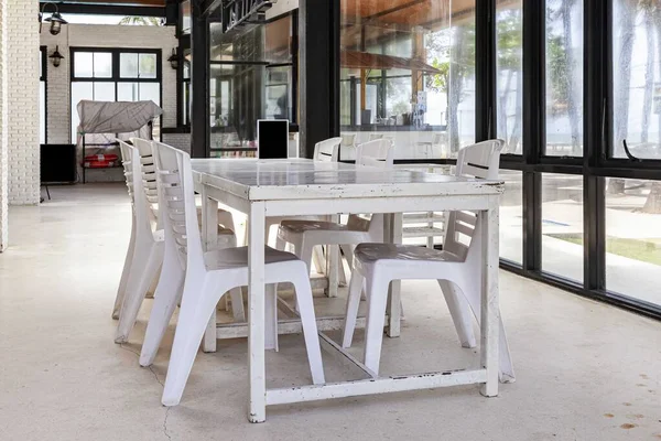 White wooden dining table by the pool inside the resort