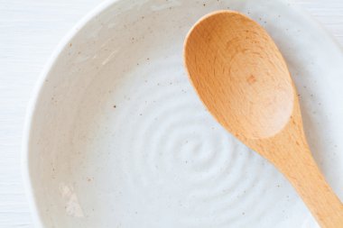 Tahta kaşık ve beyaz seramik tabak