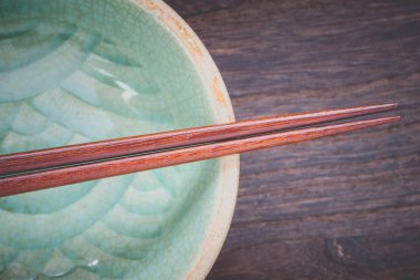 chopsticks and celadon on wood