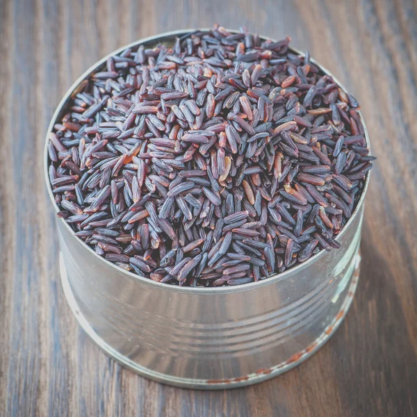 Uncooked brown rice in tin can — Stockfoto