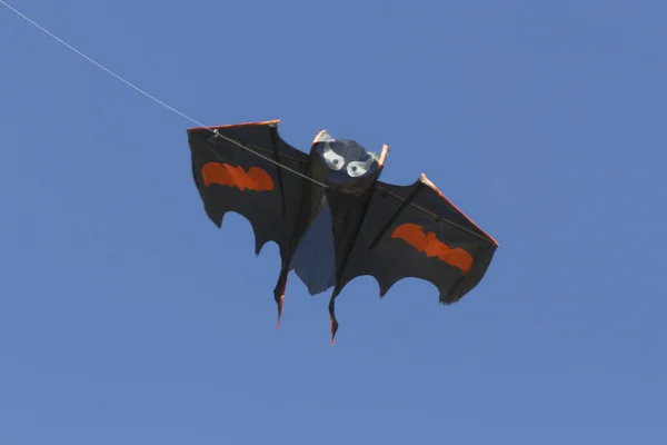 colorful kites flying  in single file in the sky