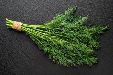 Taş bir yüzeyde bir demet dereotu, düz yatıyordu.