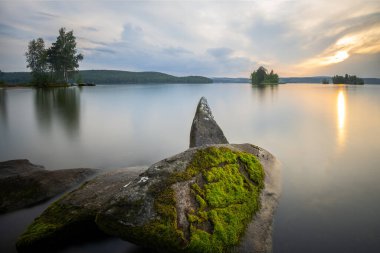Gün batımında dokulu ön plan ve uzun pozlama ile çekilen manzara