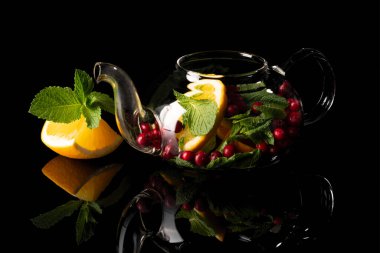 Portakallı nane çayı ve siyah arkaplanda kızılcık.