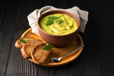 Kızarmış ekmekli sandviç ve ahşap arka planda maydanozlu kabak havyarı.