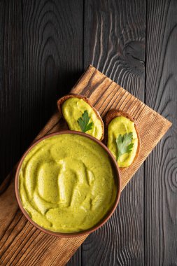 Kızarmış ekmekli sandviçler ve ahşap arka planda maydanozlu kabak havyarı.