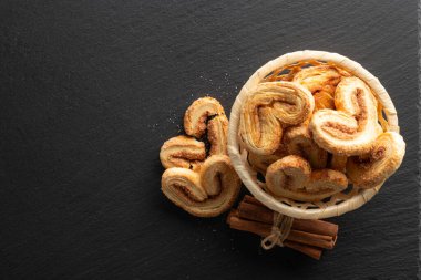Siyah taş arka planda şeker ve tarçınlı çıtır puf böreği, üst görünüm, metin için yer