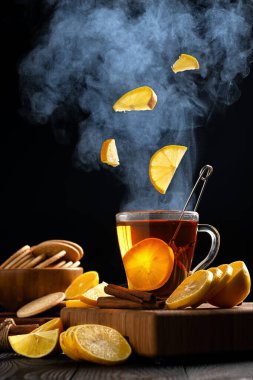 Bir kupa sıcak çaya uçan limonlarla hayat, kupanın üstünde buhar yükselir.