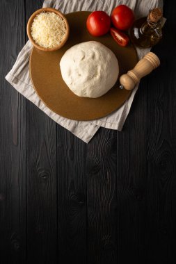 Hamur ve pizza malzemeleri ahşap arka planda, üst manzara
