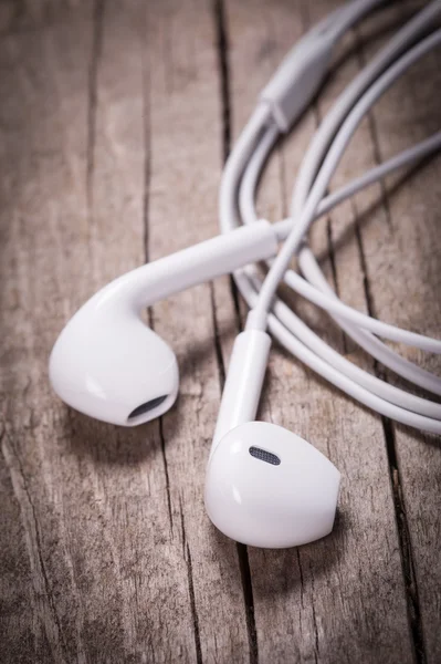 White earbuds on wooden table — Stock Photo, Image