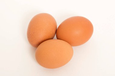 Beyaz arkaplanda üç yumurta izole edilmiş.