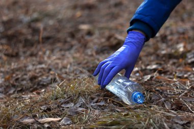 Kız plastik toplar. Çöp torbasına koyuyor. Plastik atıklardan kaynaklanan çevre kirliliği sorunu... Ekolojik kirlilik. Ekoloji sorunu.