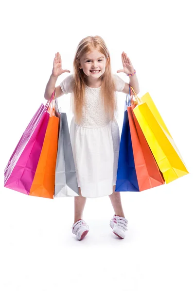 큰 다채로운 쇼핑 봉투와 함께 재미 있는 어린 소녀. — 스톡 사진