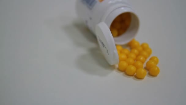 Gele pillen in een pot — Stockvideo