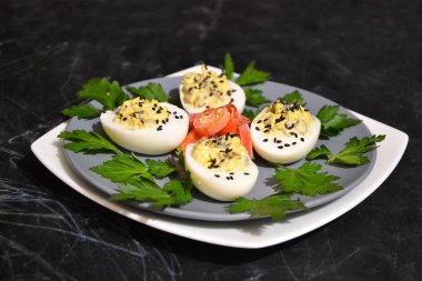 Mantar soslu haşlanmış tavuk yumurtaları, üzerine siyah susam serpiştirilmiş maydanoz ve biber serpiştirilmiş beyaz tabak, seçici odaklanma.