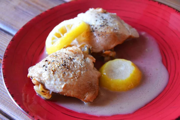 Kırmızı tabakta beyaz soslu limonla pişirilmiş Chiken, seçici odaklı.