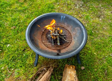 Güneybatı Missouri 'de bir bahar akşamında yeni biçilmiş yeşil çimlerin üzerinde küçük bir kamp ateşinin yakın görüntüsü.. 