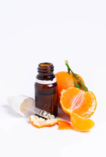 Isolado, frasco de vidro com pipeta e tangerina sobre fundo branco — Fotografia de Stock