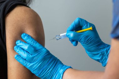 Hastaya kovid 19 aşısı yapan hemşire.