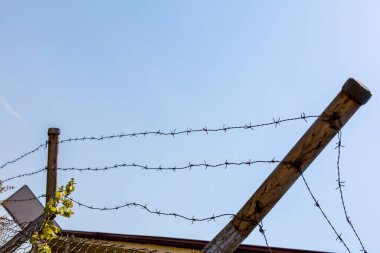 Dikenli tellerle çevrili bir bina çiti.