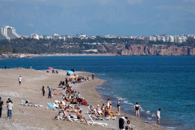Antalya, Türkiye - 117 17 2025: Antalya kıyılarında sonbahar olmasına rağmen, insanlar denize akın etmeye devam ediyor. Turistler güzel havanın tadını çıkarıyorlar..
