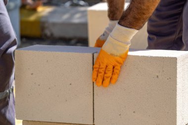 Tuğlacı çalışıyor. Havalandırmalı betondan bir duvar inşa etmek. Gasbeton duvarı