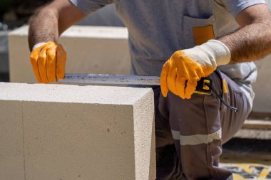 Tuğlacı çalışıyor. Havalandırmalı betondan bir duvar inşa etmek. Gasbeton duvarı