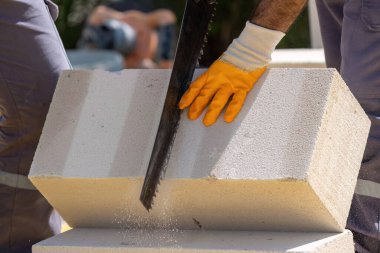 Tuğlacı çalışıyor. Havalandırmalı betondan bir duvar inşa etmek. Gasbeton duvarı