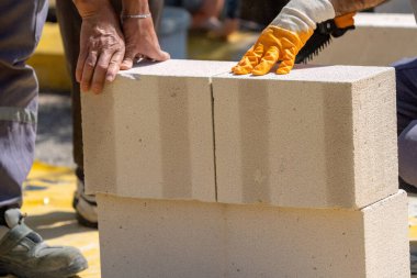 Tuğlacı çalışıyor. Havalandırmalı betondan bir duvar inşa etmek. Gasbeton duvarı