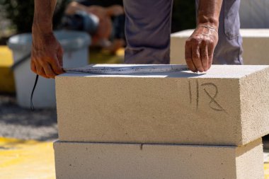 Tuğlacı çalışıyor. Havalandırmalı betondan bir duvar inşa etmek. Gasbeton duvarı