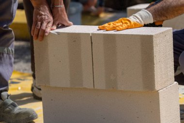 Tuğlacı çalışıyor. Havalandırmalı betondan bir duvar inşa etmek. Gasbeton duvarı