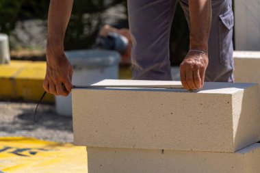 Tuğlacı çalışıyor. Havalandırmalı betondan bir duvar inşa etmek. Gasbeton duvarı