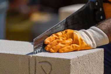 Tuğlacı çalışıyor. Havalandırmalı betondan bir duvar inşa etmek. Gasbeton duvarı