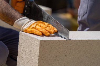 Tuğlacı çalışıyor. Havalandırmalı betondan bir duvar inşa etmek. Gasbeton duvarı